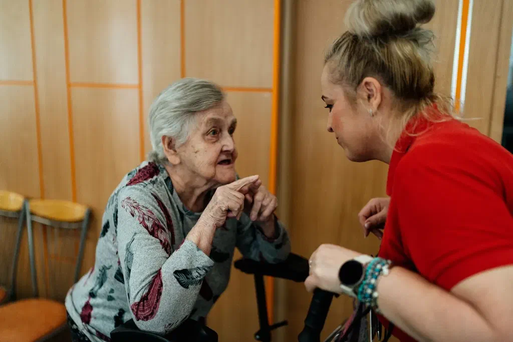 Une femme âgée discute avec une conseillère dans une salle d'accueil